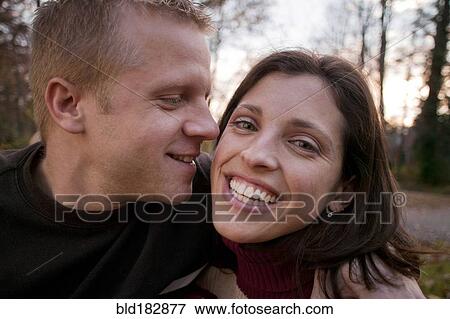 Stock Photo - Smiling couple hugging outdoors. Fotosearch