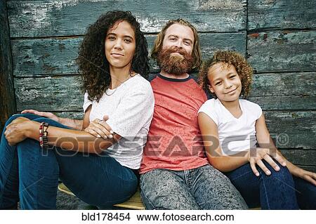 Smiling family sitting outdoors View Large Photo Image Picture - Smiling family sitting outdoors. Fotosearch