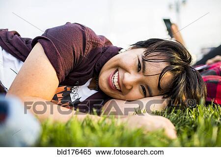 Stock Photography - Smiling woman laying in grass. Fotosearch