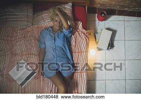Stock Photo - Smiling woman laying on bed. Fotosearch