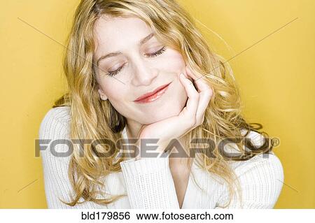 Stock Photograph - Smiling woman resting chin in hand. Fotosearch