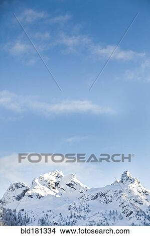 Snowy mountain tops under blue sky View Large Photo Image Picture - Snowy mountain tops under blue sky. Fotosearch