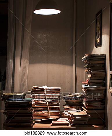 Stock Photo - Stack of books under spotlight. Fotosearch