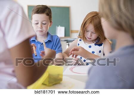 Stock Image - Students drawing in classroom. Fotosearch