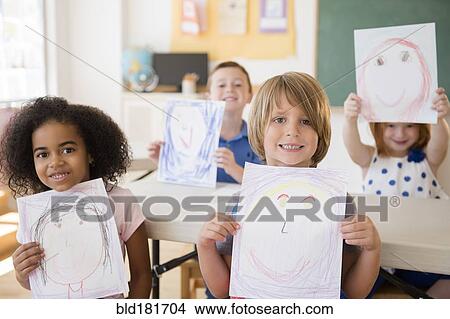Picture - Students showing drawings in classroom. Fotosearch