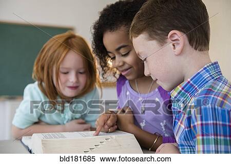 Stock Photography - Students using dictionary in classroom. Fotosearch