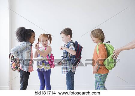Picture - Students wearing backpacks in classroom. Fotosearch