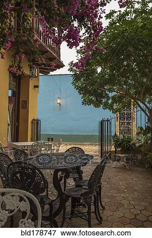 Stock Photo - Tables and flowering trees in courtyard. Fotosearch