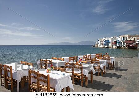 Stock Photo - Tables at waterfront cafe under blue sky. Fotosearch