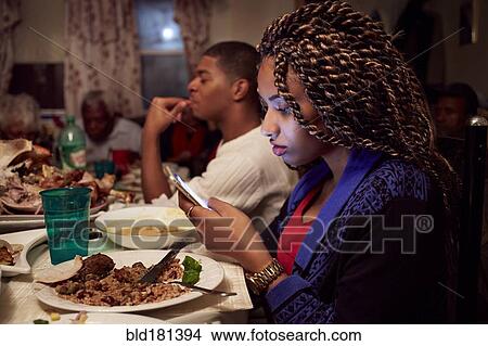 Teenage girl using cell phone at dinner table View Large Photo Image Picture - Teenage girl using cell phone at dinner table. Fotosearch