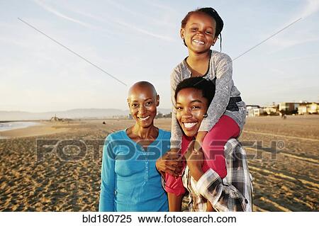 Stock Photography - Three generations of Black women smiling on beach. Fotosearch