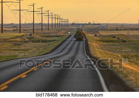 Stock Photo - Truck carrying hay bales on rural highway. Fotosearch