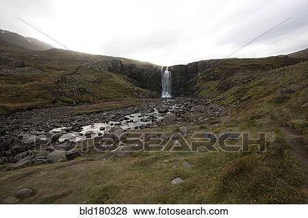 Stock Photo - Waterfall and rocky stream in remote field. Fotosearch