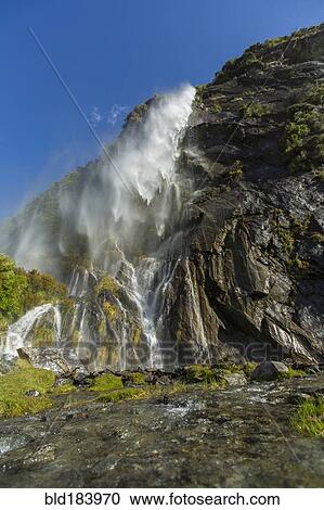 Waterfall pouring over remote cliff View Large Photo Image Stock Image - Waterfall pouring over remote cliff. Fotosearch