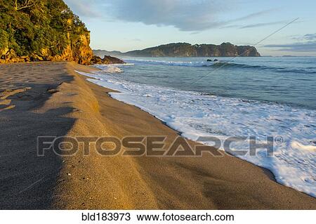 Stock Image - Waves on remote beach. Fotosearch