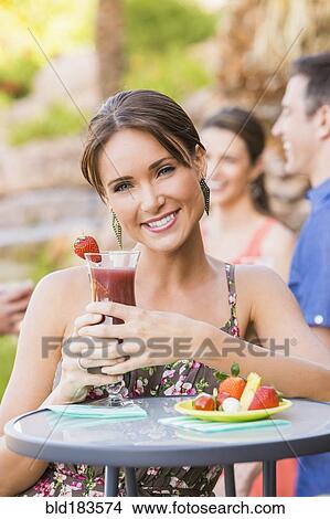 Woman drinking cocktail outdoors View Large Photo Image Picture - Woman drinking cocktail outdoors. Fotosearch