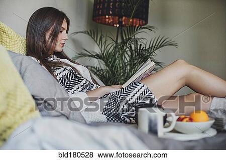 Woman reading book on bed View Large Photo Image Stock Photo - Woman reading book on bed. Fotosearch