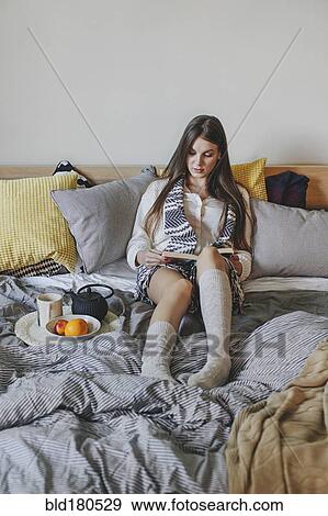 Woman reading book on bed View Large Photo Image Stock Photo - Woman reading book on bed. Fotosearch