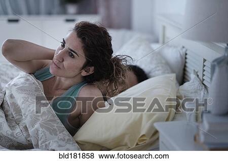 Woman rubbing her neck in bed View Large Photo Image Stock Photo - Woman rubbing her neck in bed. Fotosearch