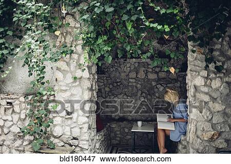 Woman sitting in stone patio View Large Photo Image Stock Photo - Woman sitting in stone patio. Fotosearch