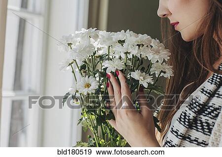Stock Photo - Woman smelling flowers. Fotosearch