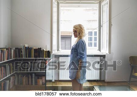 Woman standing in living room View Large Photo Image Stock Photo - Woman standing in living room. Fotosearch