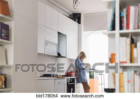 Woman using digital tablet in kitchen View Large Photo Image Picture - Woman using digital tablet in kitchen. Fotosearch