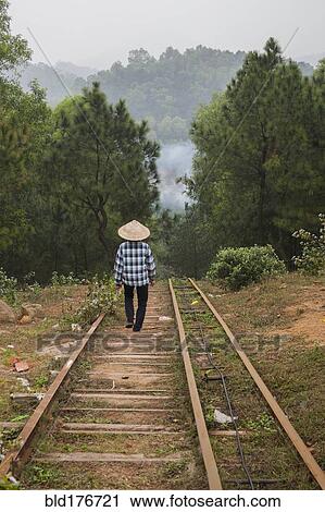 Stock Image - Woman walking on steps on rural hillside. Fotosearch