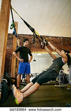 Woman working out with trainer in gymnasium View Large Photo Image Picture - Woman working out with trainer in gymnasium. Fotosearch