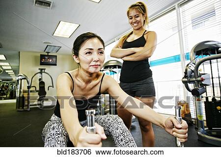 Woman working out with trainer in gymnasium View Large Photo Image Stock Photograph - Woman working out with trainer in gymnasium. Fotosearch