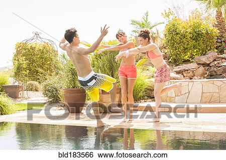 Women pushing man into swimming pool View Large Photo Image Stock Photograph - Women pushing man into swimming pool. Fotosearch