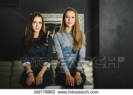 Stock Image - Women sitting on table in restaurant. Fotosearch