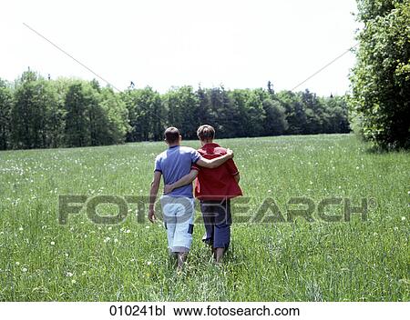 a gay couple walking in the grass, view from behind View Large Photo Image Stock Image - a gay couple walking in the grass, view from behind. Fotosearch