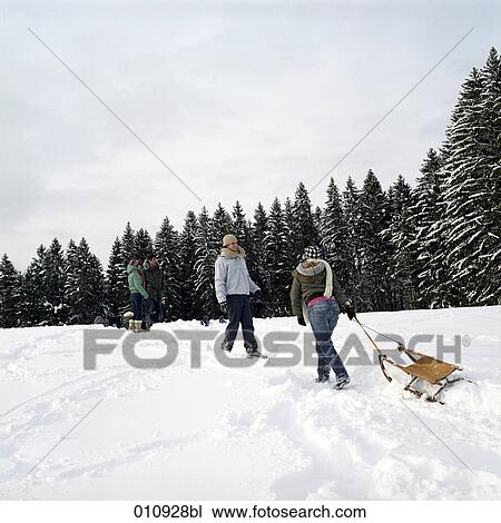 Stock Image - a teenage couple sledging. Fotosearch