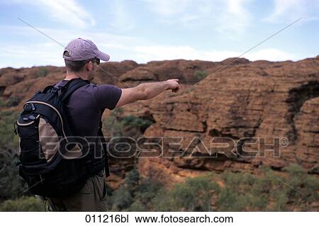 Stock Image - backpacker pointing towards canyon. Fotosearch