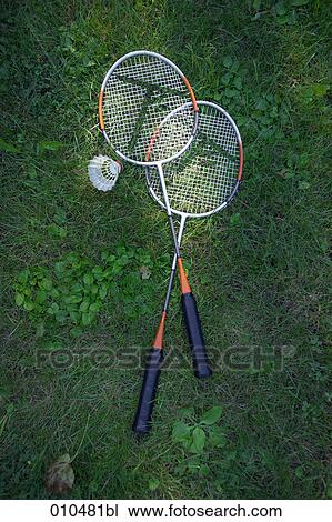 Stock Image - badminton ball and two racquets on grass. Fotosearch