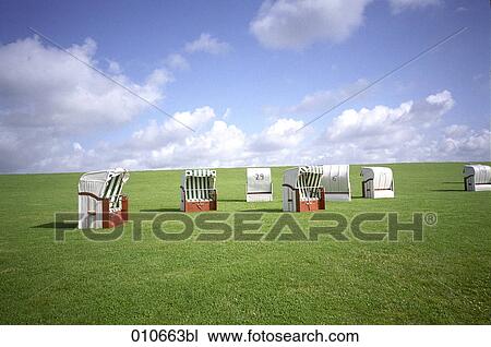 Stock Image - beach chairs standing on a meadow. Fotosearch