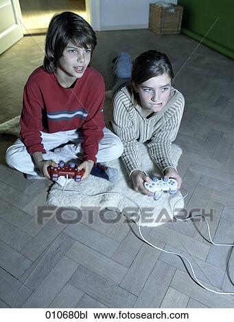 Stock Image - boy and girl playing computer game with controllers. Fotosearch