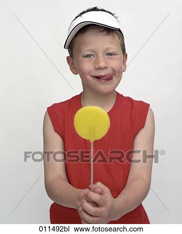 Stock Image - boy looking forward to eat lollipop. Fotosearch