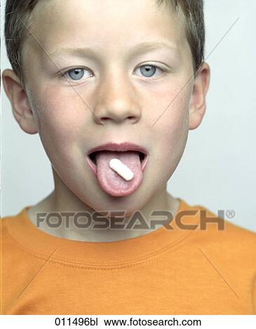 Stock Image - boy opening his mouth to display tablet on his tongue. Fotosearch