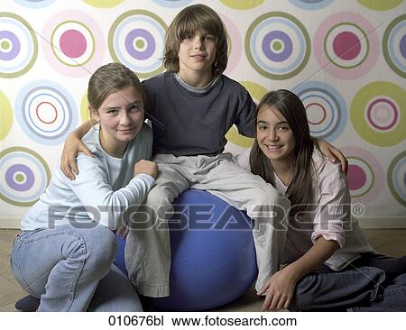 boy sitting on blue ball putting his arms around two girls View Large Photo Image Stock Image - boy sitting on blue ball putting his arms around two girls. Fotosearch