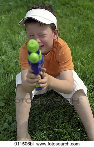 boy sitting on grass, aiming with water pistol View Large Photo Image Stock Image - boy sitting on grass, aiming with water pistol. Fotosearch