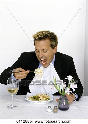 Stock Image - businessman eating with mouth wide open. Fotosearch