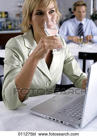 Stock Image - businesswoman drinking a glass of water. Fotosearch