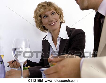 Stock Image - businesswoman listening to colleague during lunch. Fotosearch