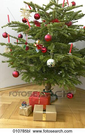 Stock Image - christmas presents under decorated christmas tree. Fotosearch