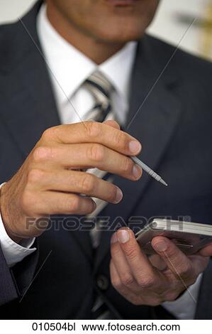 Stock Image - close-up of businessman using an electronic organizer. Fotosearch