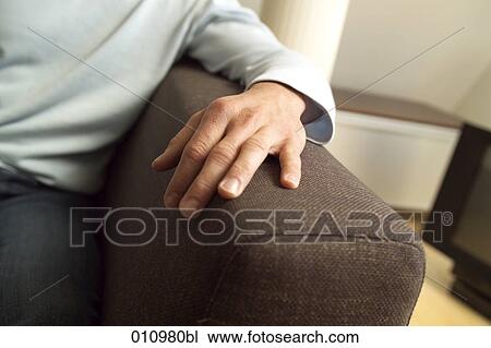 Close-up of male hand resting on armrest of sofa View Large Photo Image Stock Image - Close-up of male hand resting on armrest of sofa. Fotosearch