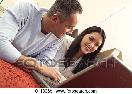 Close-up of young couple working with laptop computer on the floor View Large Photo Image Stock Image - Close-up of young couple working with laptop computer on the floor. Fotosearch