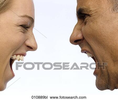 Stock Image - close-up portrait of mature man and young woman shouting at each other. Fotosearch